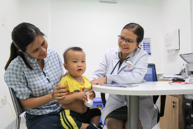 bé được khám sàng lọc miễn phí trước khi tiêm
