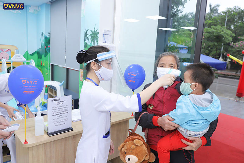 đo nhiệt độ trước khi tiêm phòng