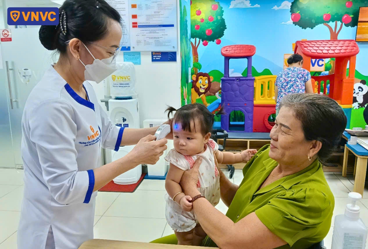 đo nhiệt độ cho trẻ trước khi tiêm