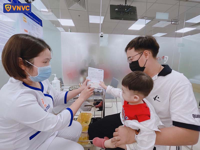 bé đi tiêm chủng vắc xin