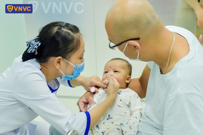 cho bé uống vắc xin