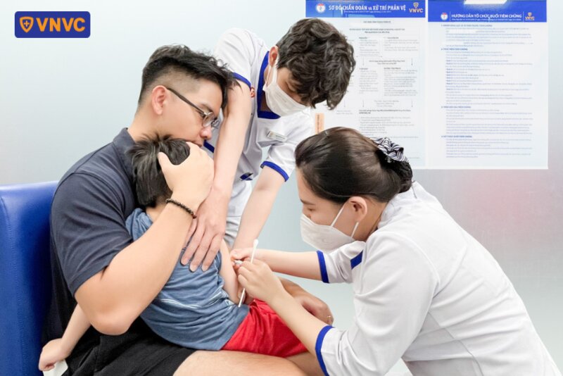 bố đưa bé trai đi tiêm vắc xin