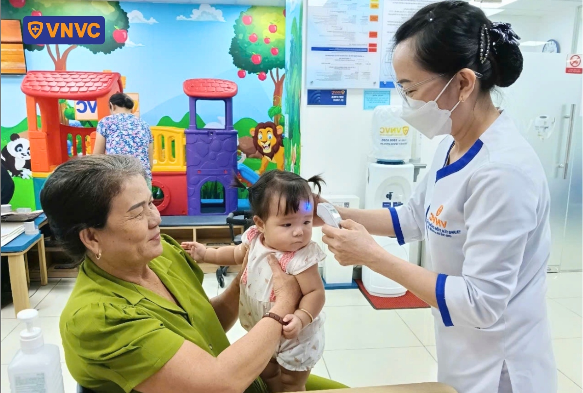 nhân viên y tế đo nhiệt độ cho trẻ em