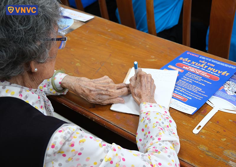 cụ bà ghi các kiến thức tư vấn