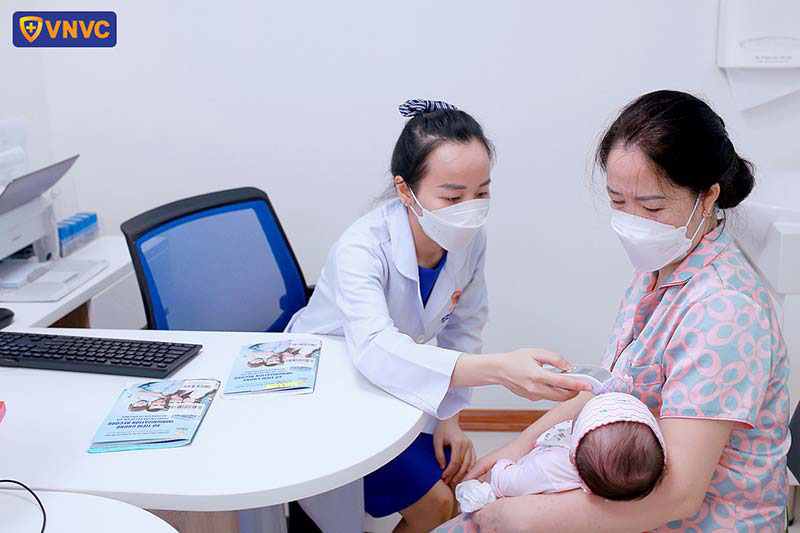 bác sĩ đo thân nhiệt cho trẻ