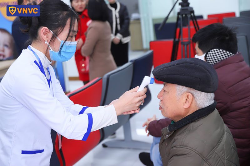 điều dưỡng đo thân nhiệt cho khách hàng