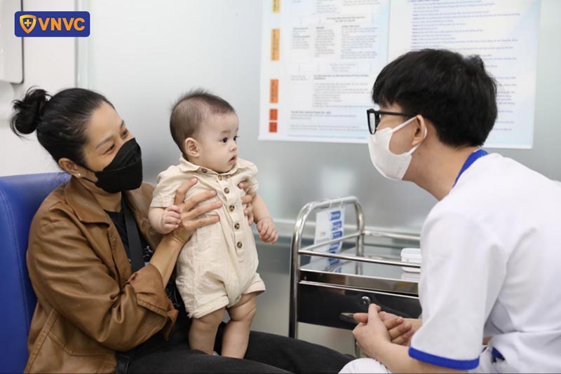 điều dưỡng trò chuyện với bé trước tiêm