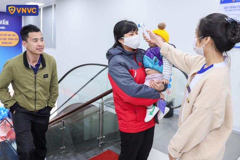 nhân viên đo thân nhiệt cho khách hàng