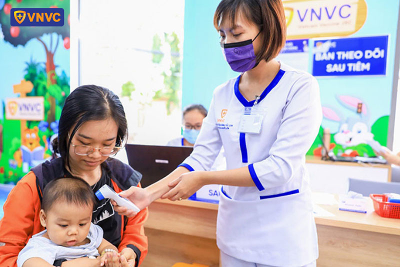 nhân viên vnvc bình tân đo thân nhiệt cho khách hàng