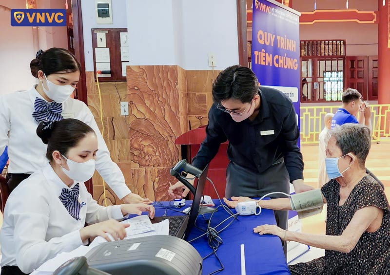 nhân viên vnvc kiểm tra sức khỏe trước tiêm vắc xin