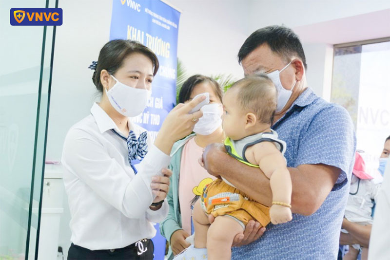 nhân viên vnvc mỹ tho đo thân nhiệt cho khách hàng