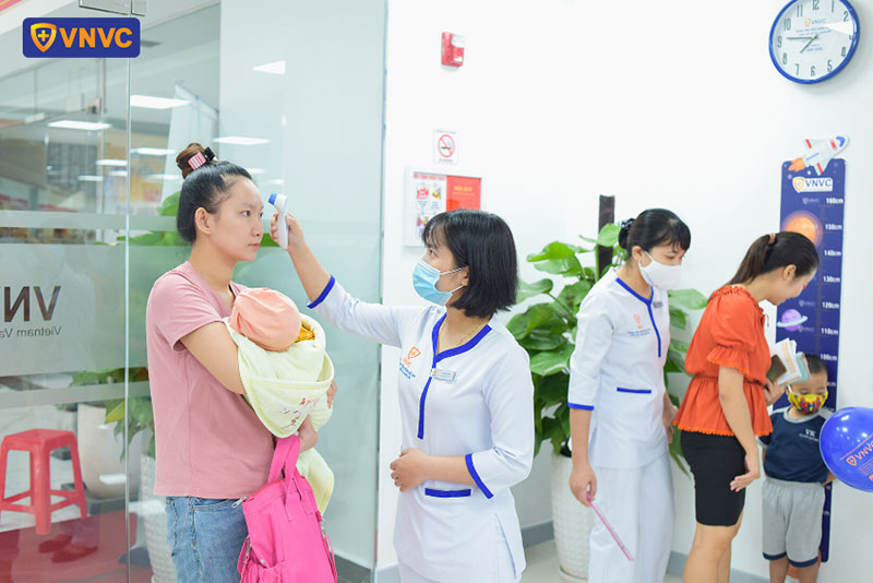 nhân viên vnvc vũng tàu đo thân nhiệt cho khách hàng