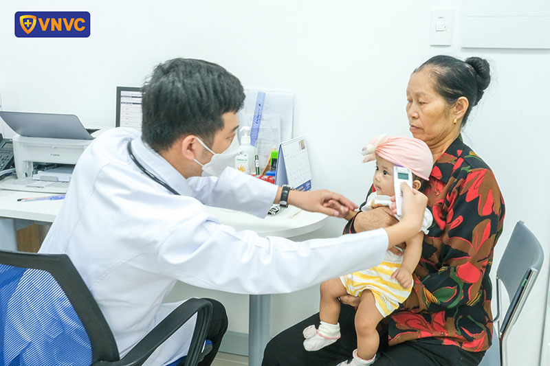 bác sĩ vnvc thạnh lộc đo thân nhiệt cho bé