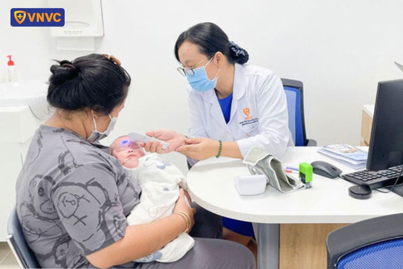 bác sĩ vnvc vĩnh lộc đo thân nhiệt cho trẻ