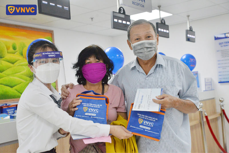 khách hàng nhận giấy chứng nhận tiêm chủng từ nhân viên vnvc