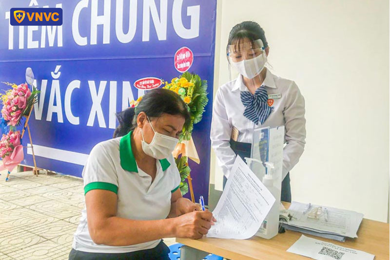 nhân viên vnvc bình phước hướng dẫn khách hàng đăng ký tiêm