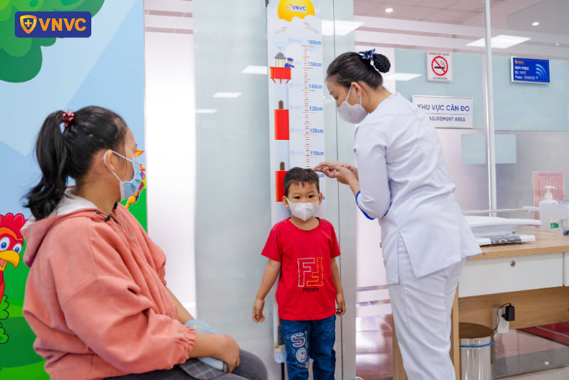 nhân viên vnvc chợ gạo đo chiều cao cho trẻ