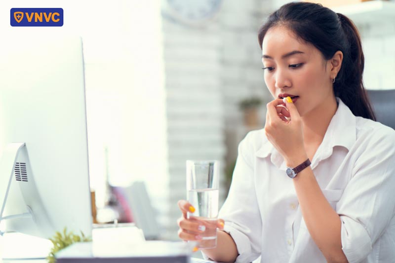 cô gái uống thuốc kháng sinh