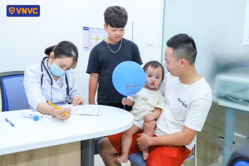 bác sĩ kiểm tra thông tin tiêm chủng của bé