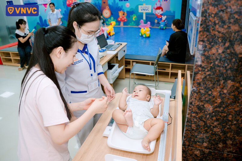 cân trọng lượng trẻ trước khi tiêm phòng