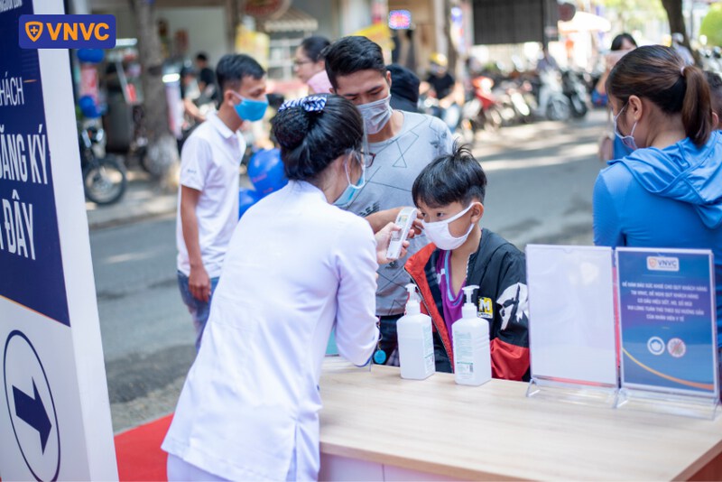 điều dưỡng thực hiện đo nhiệt độ cho bé