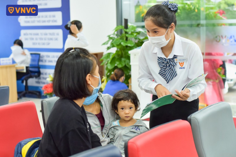 nhân viên trao đổi giá vắc xin với phụ huynh