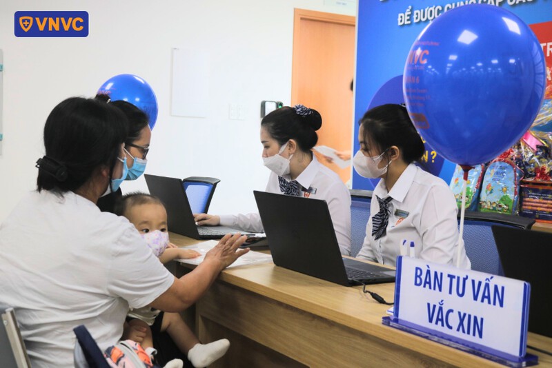 nhân viên tư vấn vắc xin cho phụ huynh