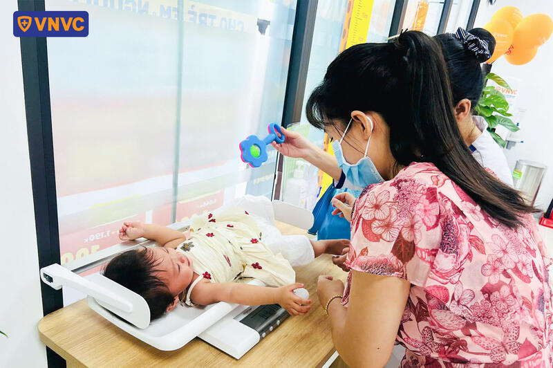 cân đo trẻ nhỏ trước khi tiêm phòng