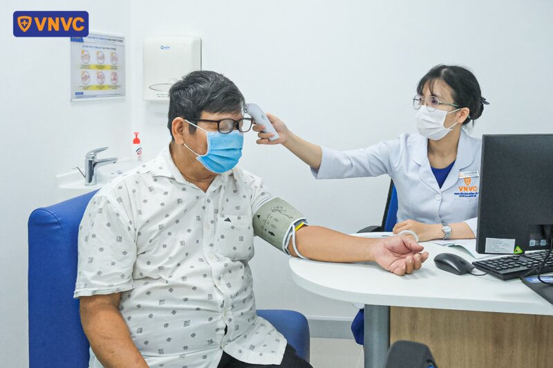 đo nhiệt độ trước khi tiêm vắc xin