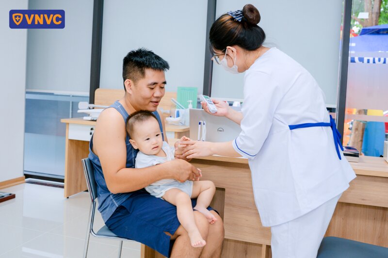 đo nhiệt độ cho bé sau tiêm