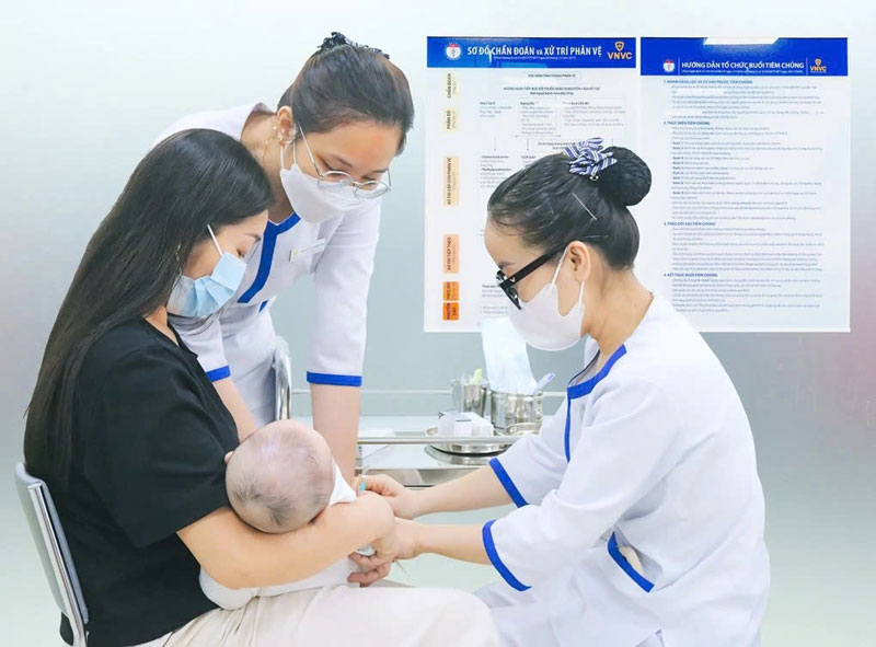 mẹ đưa bé đi tiêm vắc xin