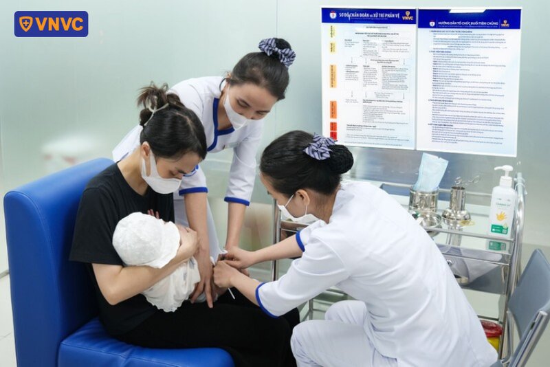 y tá tiêm vắc xin cho trẻ sơ sinh