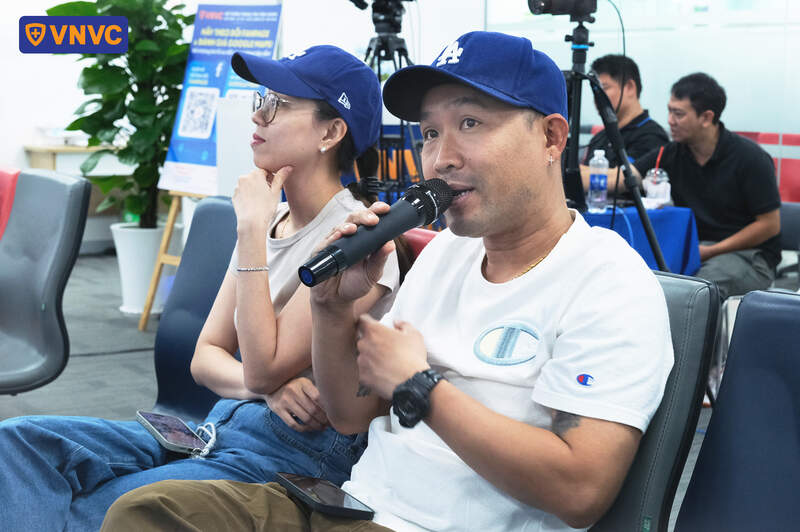 người ngồi cầm micro nói