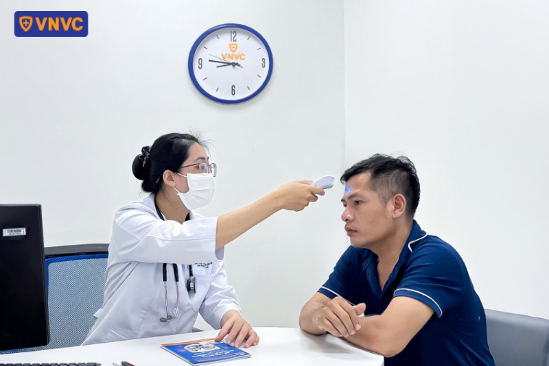 nhân viên đo nhiệt độ cơ thể cho khách hàng