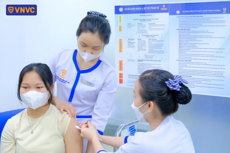 điều dưỡng tiêm vắc xin cho bé gái