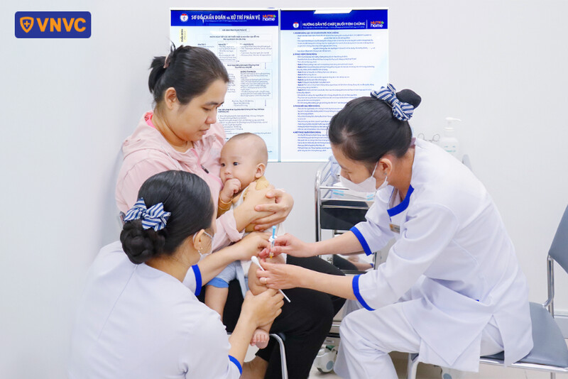 mẹ đưa bé đi tiêm vắc xin