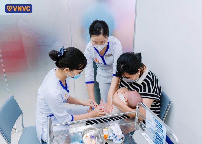 mẹ đưa trẻ đi tiêm vắc xin