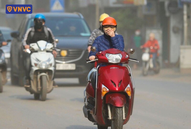 người đi xe máy trong khói bụi ô nhiễm