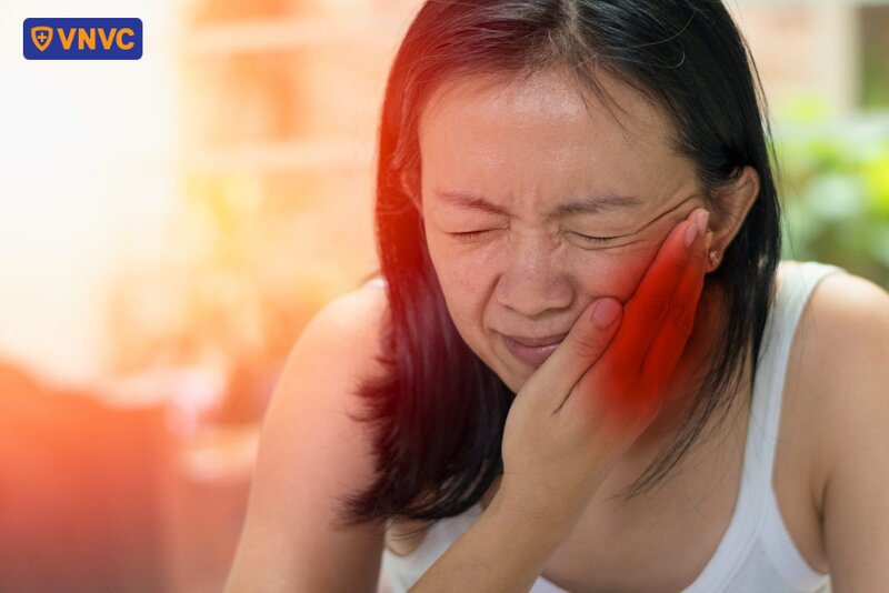 người phụ nữ ôm vùng quai hàm bị đau