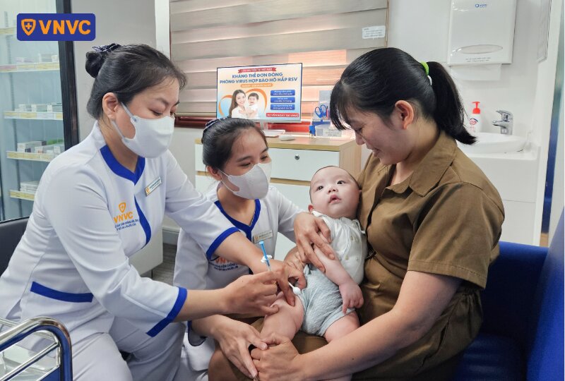 nhân viên tiêm cho em bé