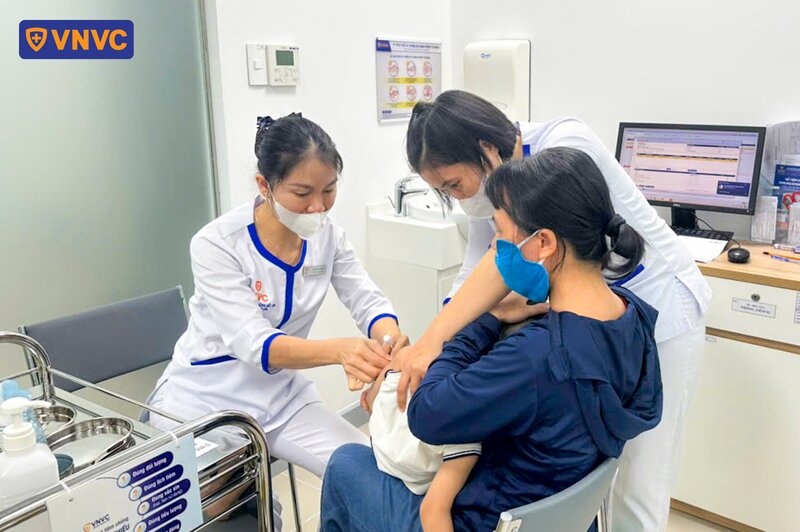 nhân viên y tế tiêm phòng cho trẻ