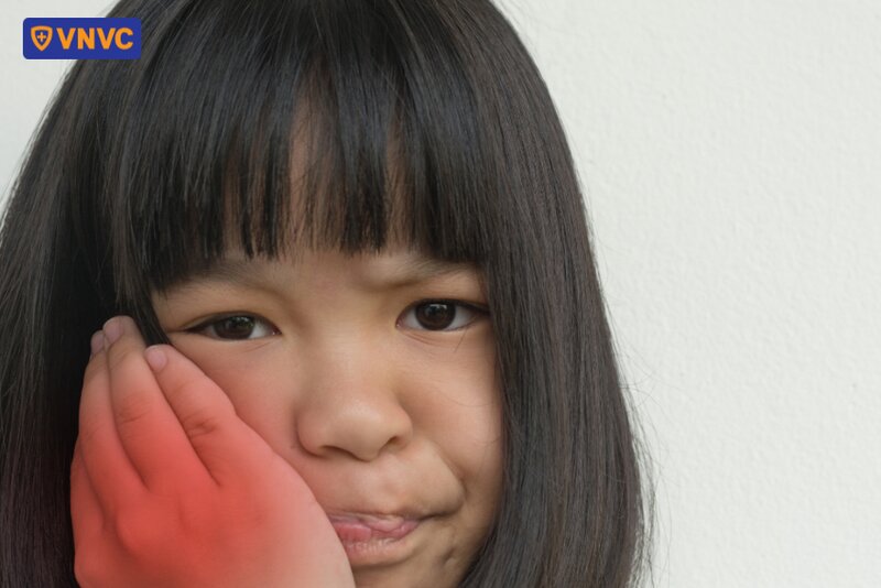 trẻ ôm vùng quai hàm bị đau