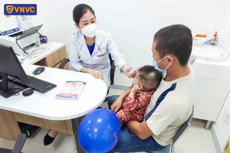 bác sĩ đo nhiệt độ cho trẻ