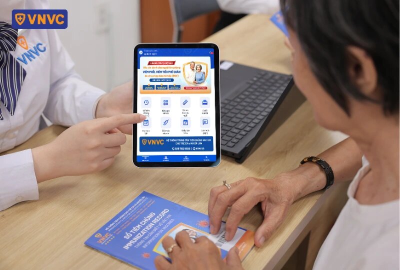 nhân viên chỉ vào màn hình app vnvc