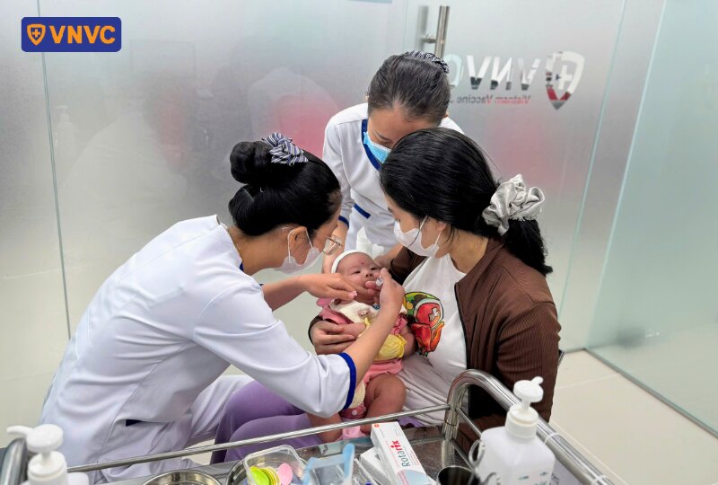 nhân viên y tế vnvc cho trẻ uống vaccine