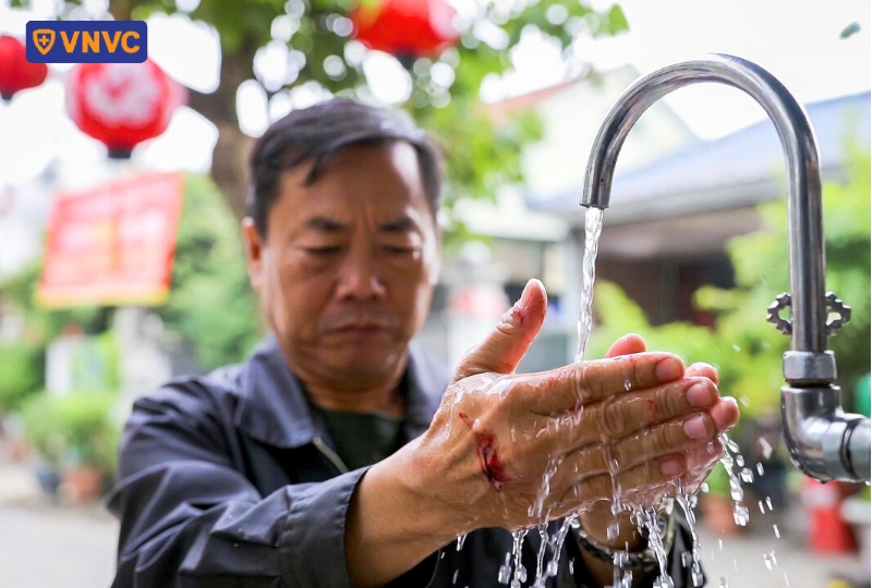 rửa vết thương dưới vòi nước