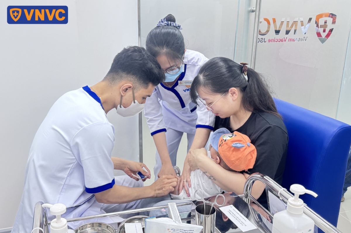 bác sĩ vệ sinh vết tiêm cho bé