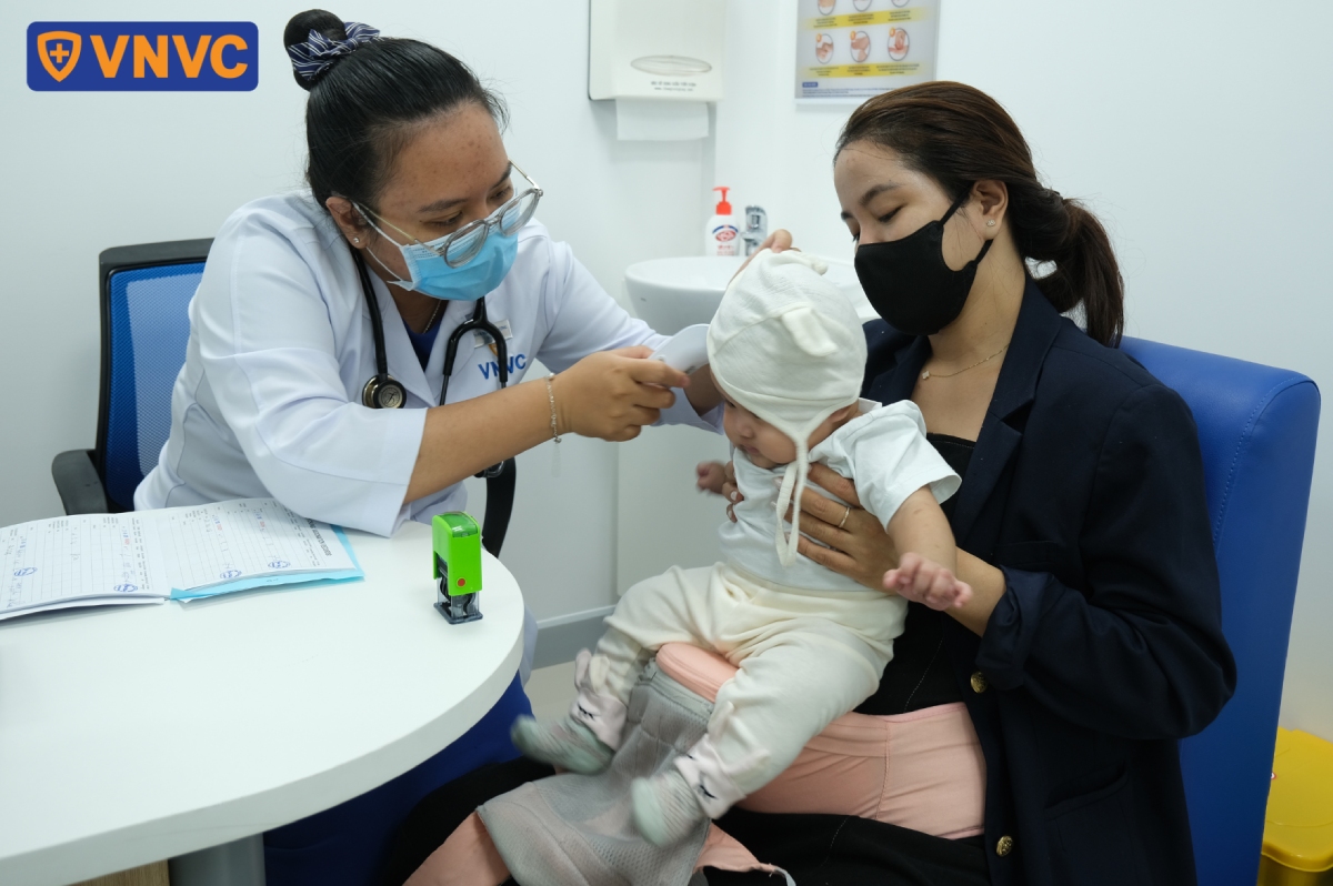 nhân viên đo nhiệt độ cho bé