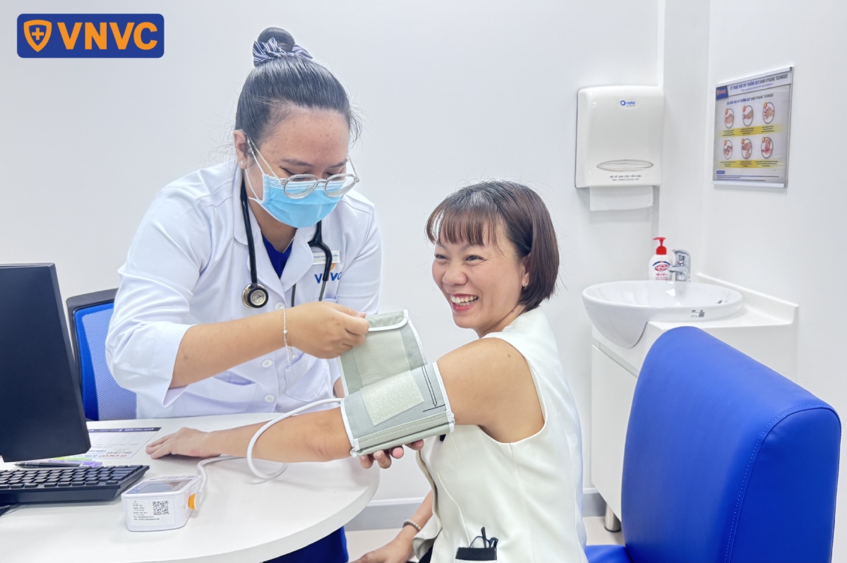 nhân viên y tế đo huyết áp cho khách hàng