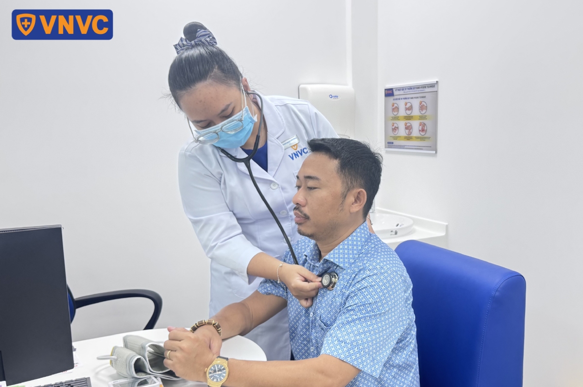 nhân viên y tế kiểm tra sức khỏe trước khi tiêm
